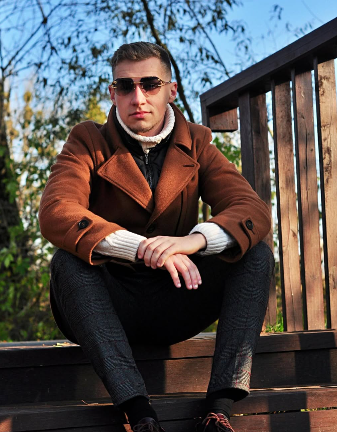 Jakub Kasperek siedzący na schodach w parku