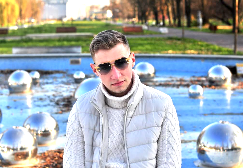 Jakub Kasperek przy fontannie w Lublinie, biała kurtka